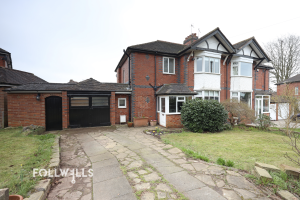 Semi-detached red brick home with driveway, garage and front garden in a residential area