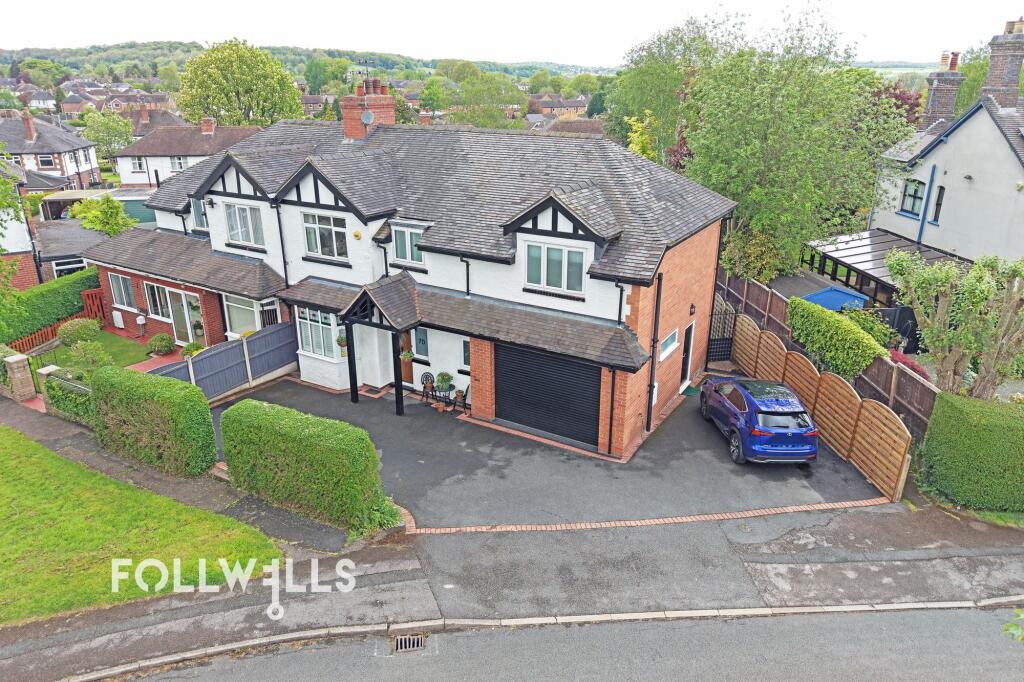 Exterior view of a semi-detached property on Myott Avenue with a driveway, garage and neatly trimmed front hedges.